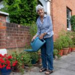 O bunică de 89 de ani este obligată de primărie să-și distrugă mica grădină cu flori de pe trotuar, după ce a îngrijit-o 25 de ani din banii ei: „Nu o suportă”